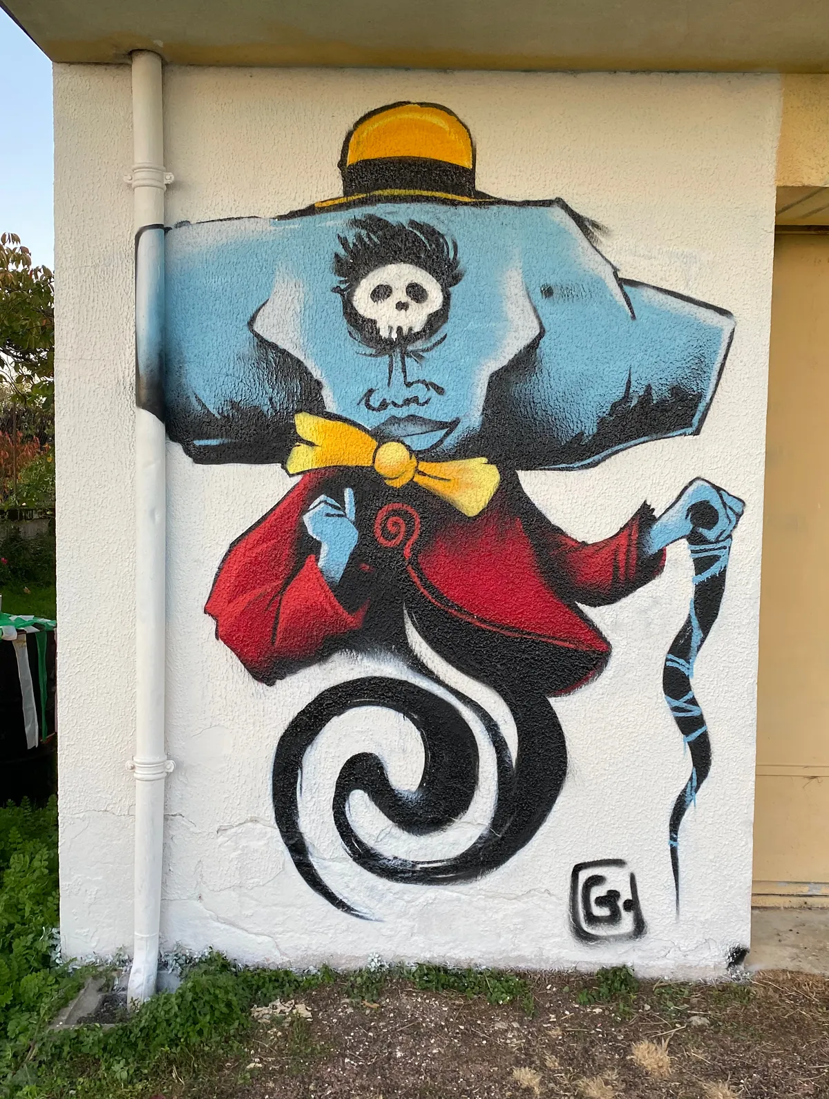 Graffiti d'un dandy avec une tête d'enclume sur un mur de Saintes